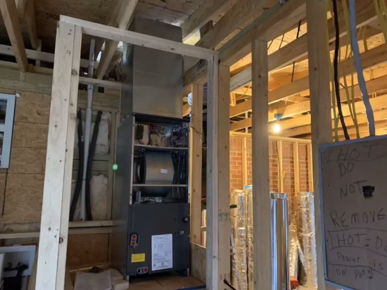 HVAC technician performing a new heating system replacement and furnace installation in a residential home under construction.
