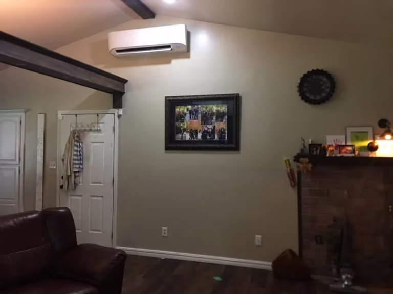 Professional ductless HVAC system installation in a residential living room by Roman expert technicians
