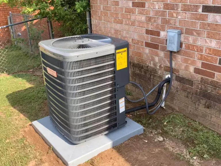 New residential air conditioner condenser unit installed outside a brick home.